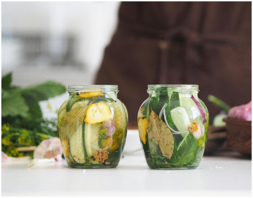 Two glass jars filled with homemade pickled cucumb