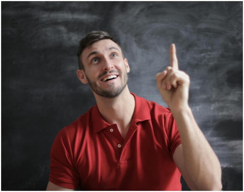 Happy young man in a red polo shirt smiling and po