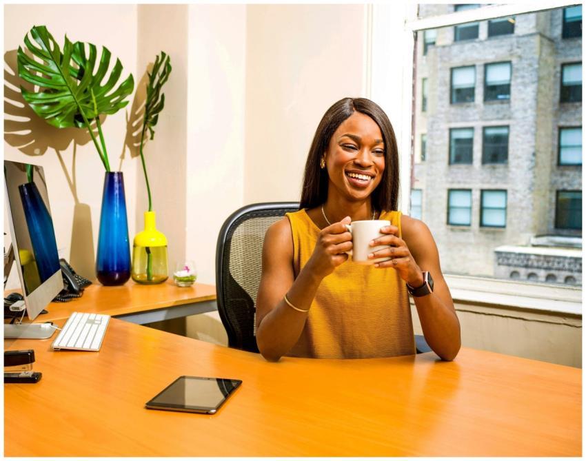 Confident woman in office attire enjoying a coffee