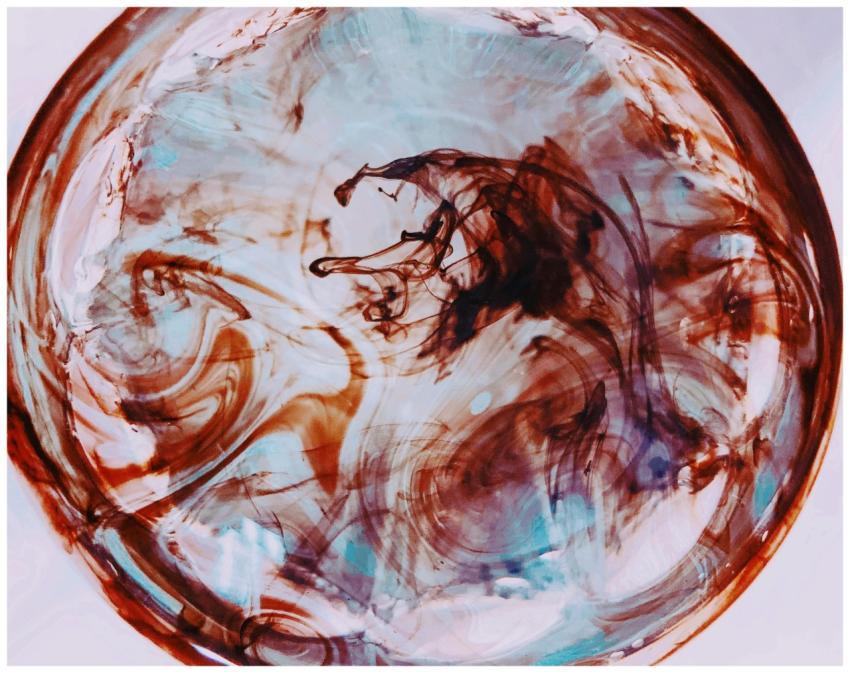 Vibrant abstract close-up of swirling paint in a c