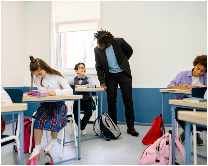 A teacher interacts with students in a bright clas