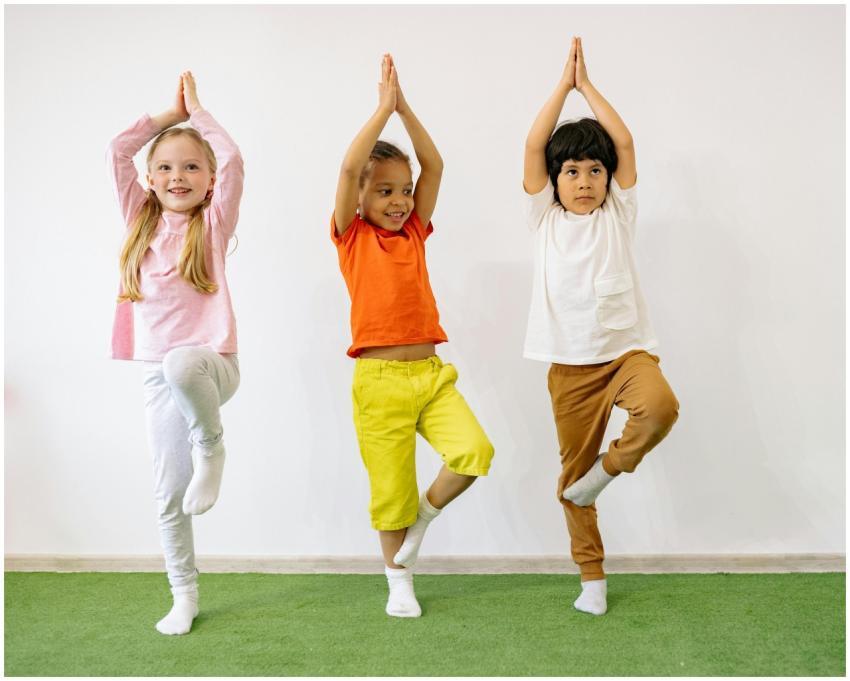 Three diverse children practicing yoga indoors, sh