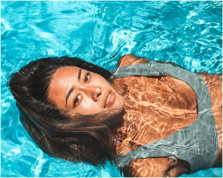 Close-up of a woman relaxing in a clear blue swimm