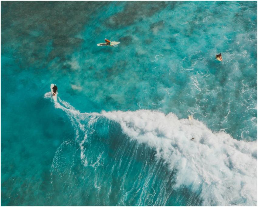 Breathtaking aerial shot of surfers riding waves i