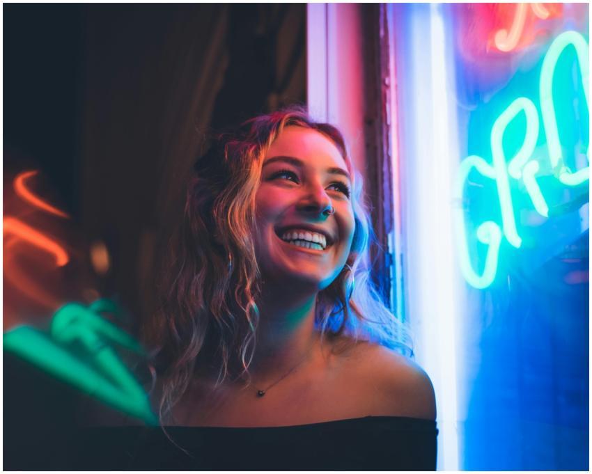 Portrait of a smiling woman with neon lights illum