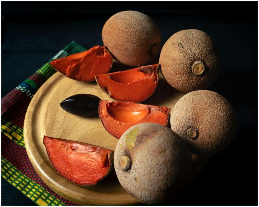 Close-up of fresh mamey sapote fruit sliced on a w