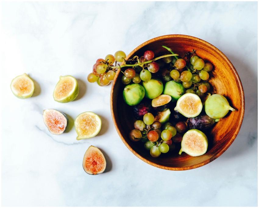 A vibrant and fresh bowl of green grapes and figs