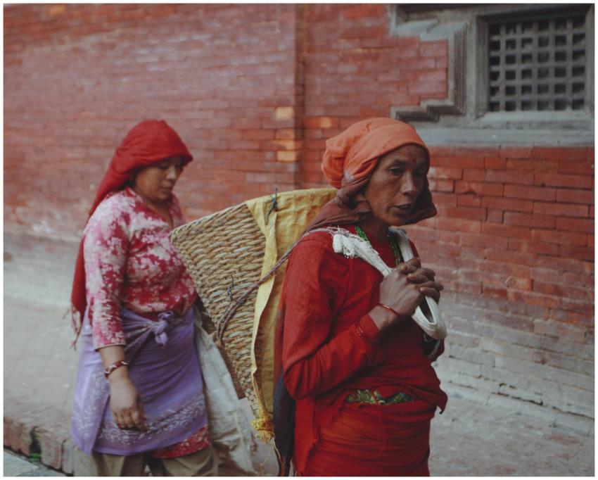 Women in traditional attire carrying baskets along