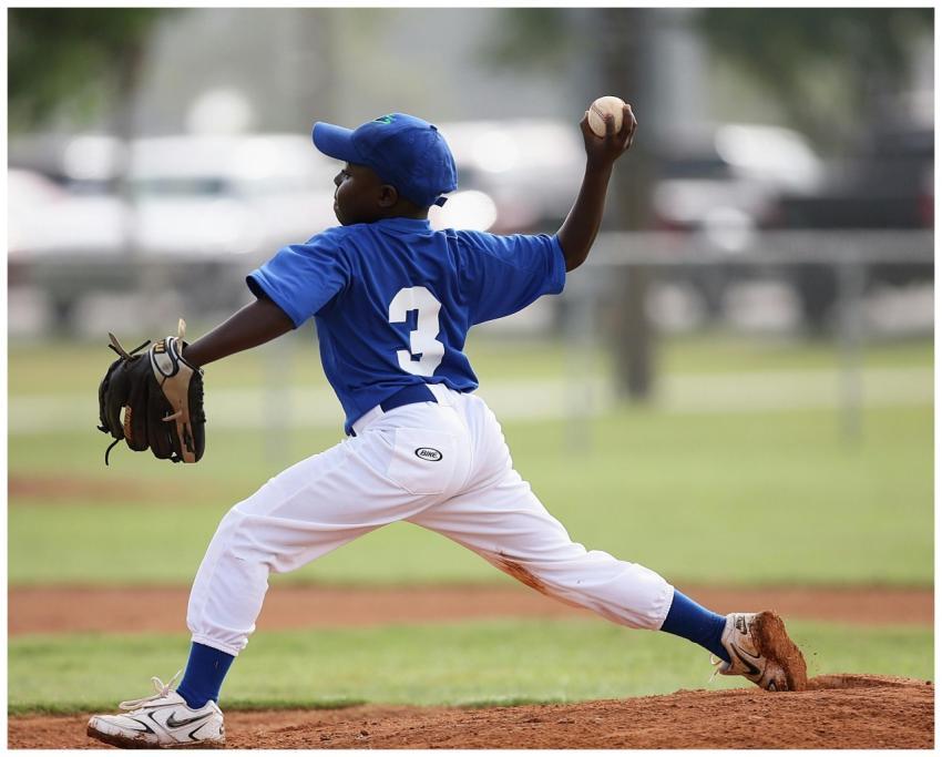 Young player pitching in a youth baseball game on