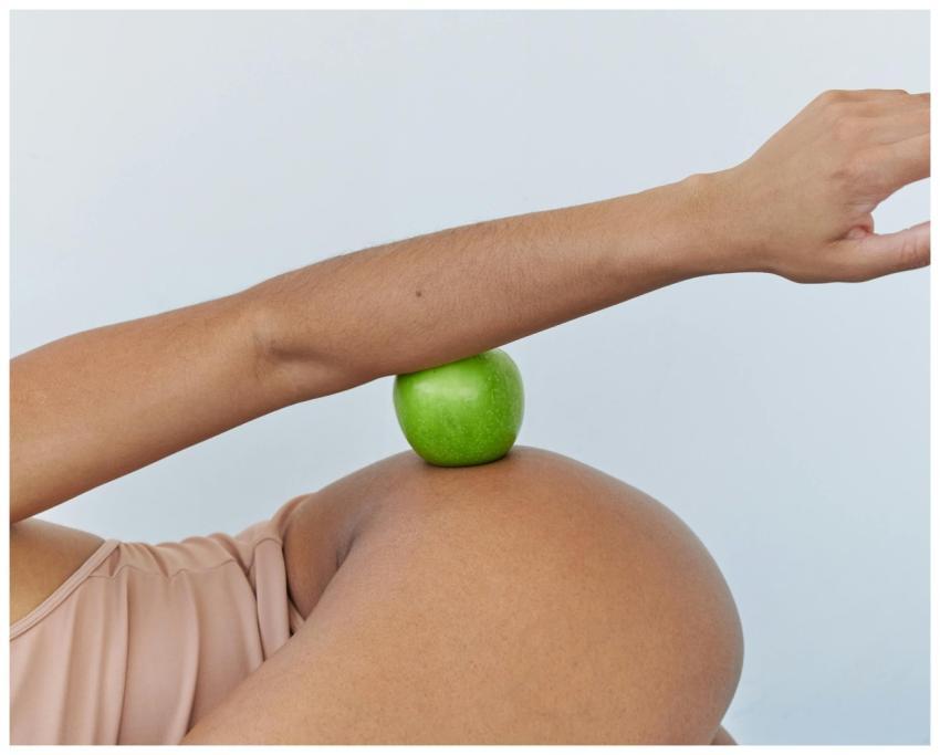 Creative portrayal of pregnancy with a green apple