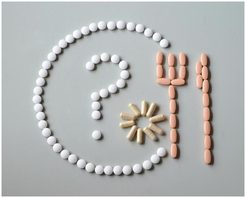 Artistic layout of various pills forming a questio