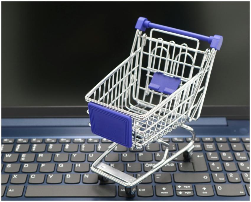 A mini shopping cart placed on a laptop keyboard,