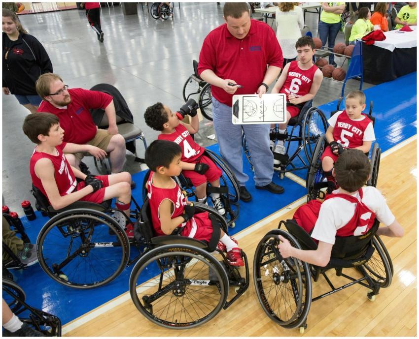 Young wheelchair basketball players and coach stra