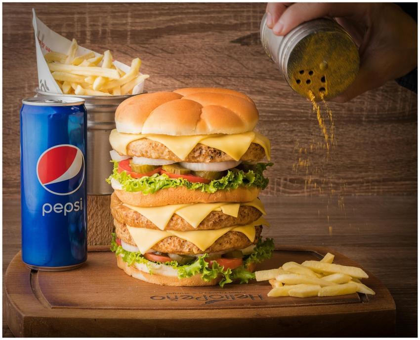 Delicious triple cheeseburger with fries and Pepsi