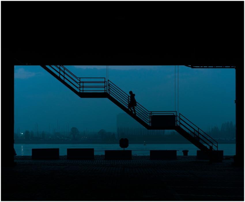 Silhouetted woman walking up stairs in an urban se