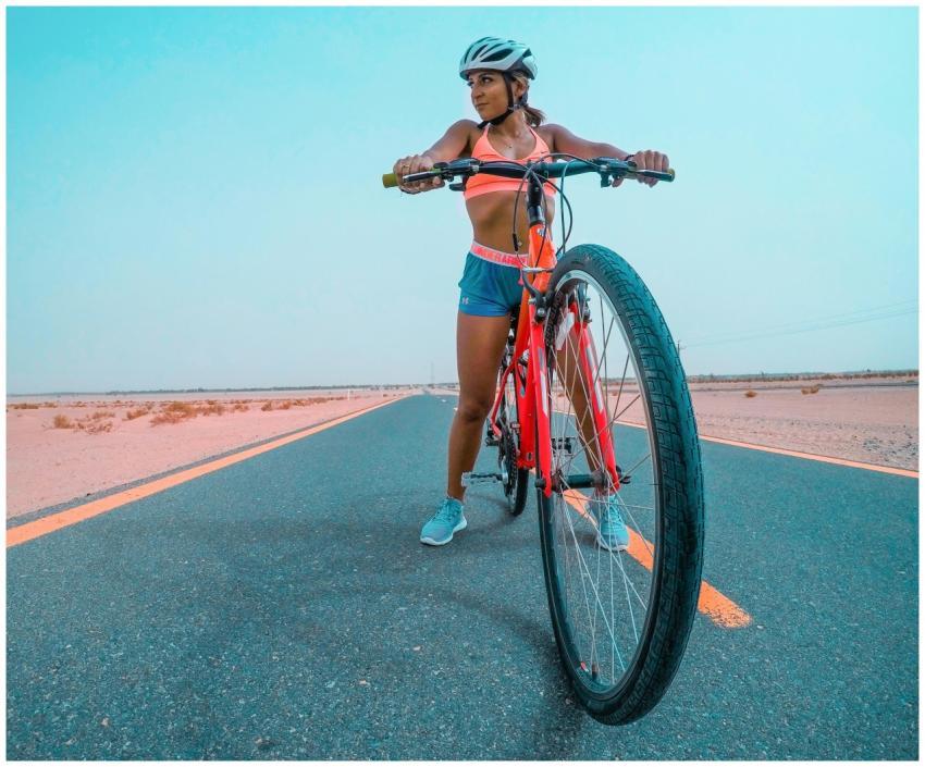 A woman cyclist in athletic gear on a bike in the