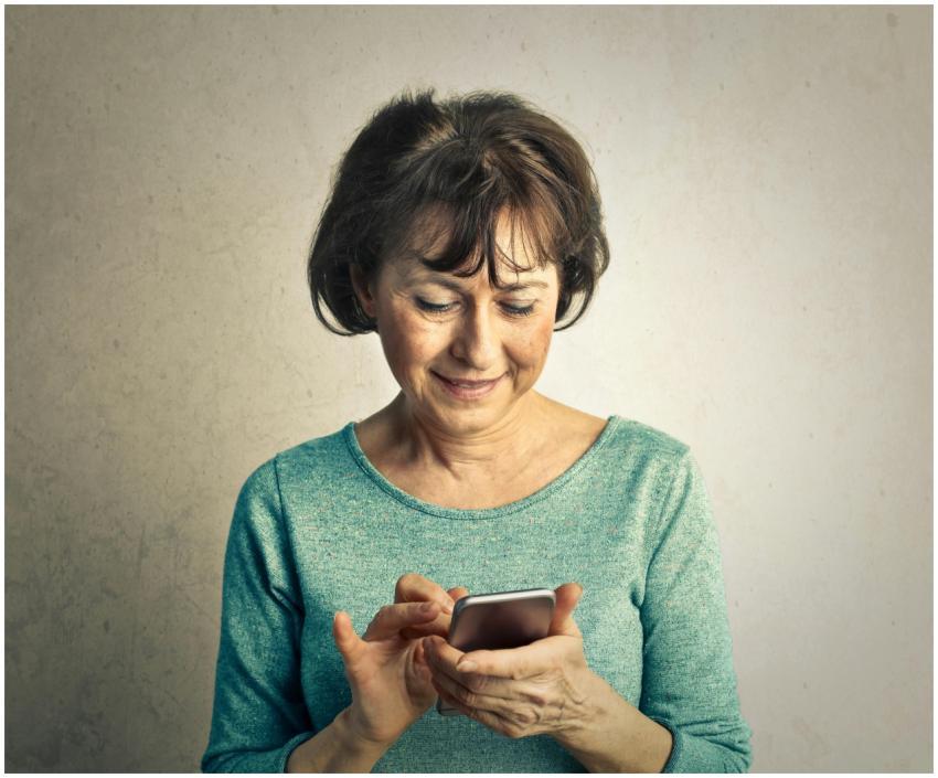 A senior woman smiling as she interacts with her s