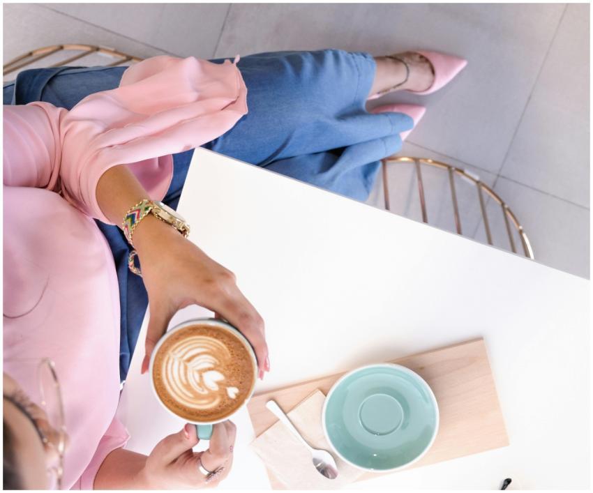 Stylish woman enjoying a cappuccino with latte art
