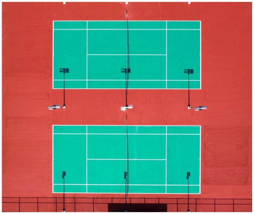 Bright aerial shot of two tennis courts on a sunny