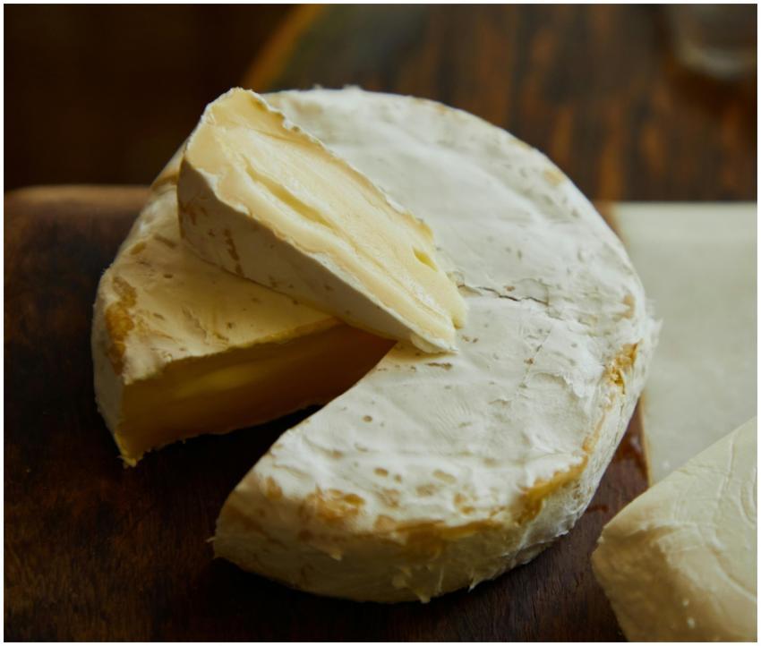 Delicious Camembert cheese wheel and slice showing