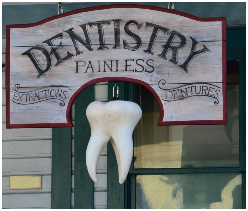 Classic dental sign with a hanging tooth, advertis