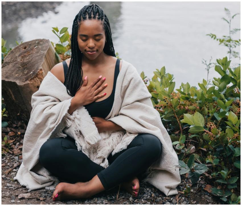 A woman practicing mindful meditation outdoors by