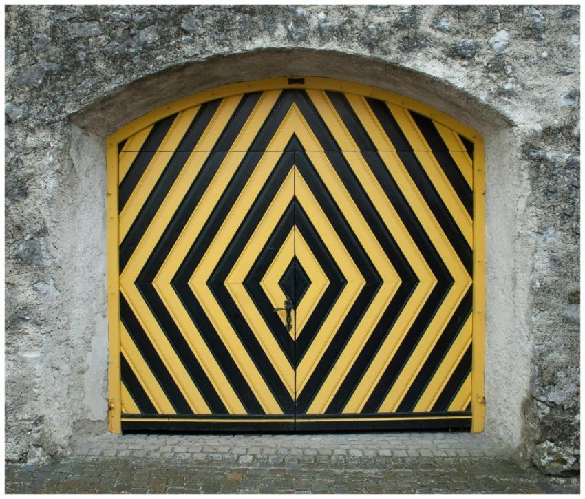 A striking black and yellow striped gate on a weat