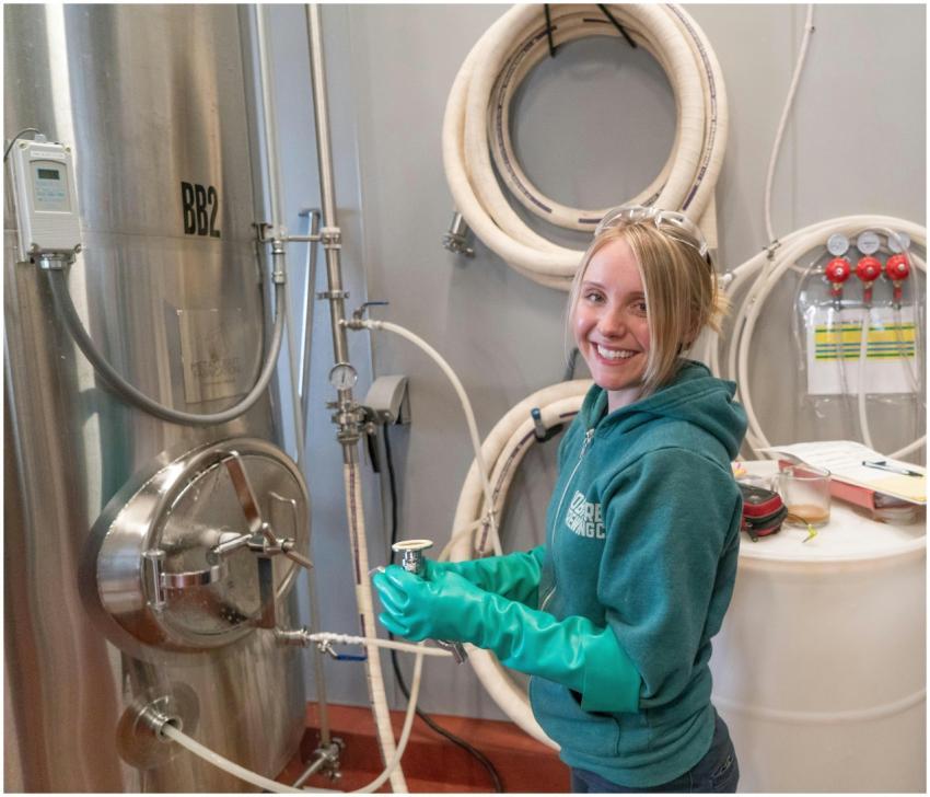 A woman in a green jacket and gloves working in a