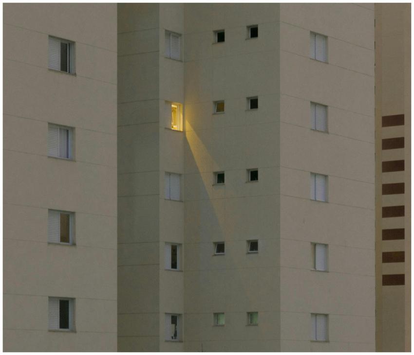 A modern apartment building facade at night with o