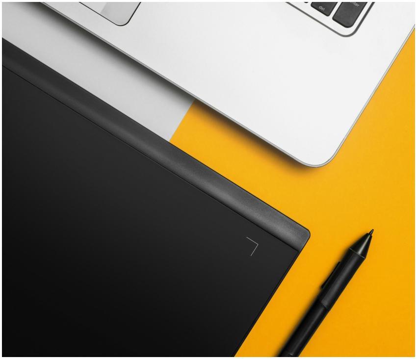 Overhead view of a laptop and graphics tablet on a