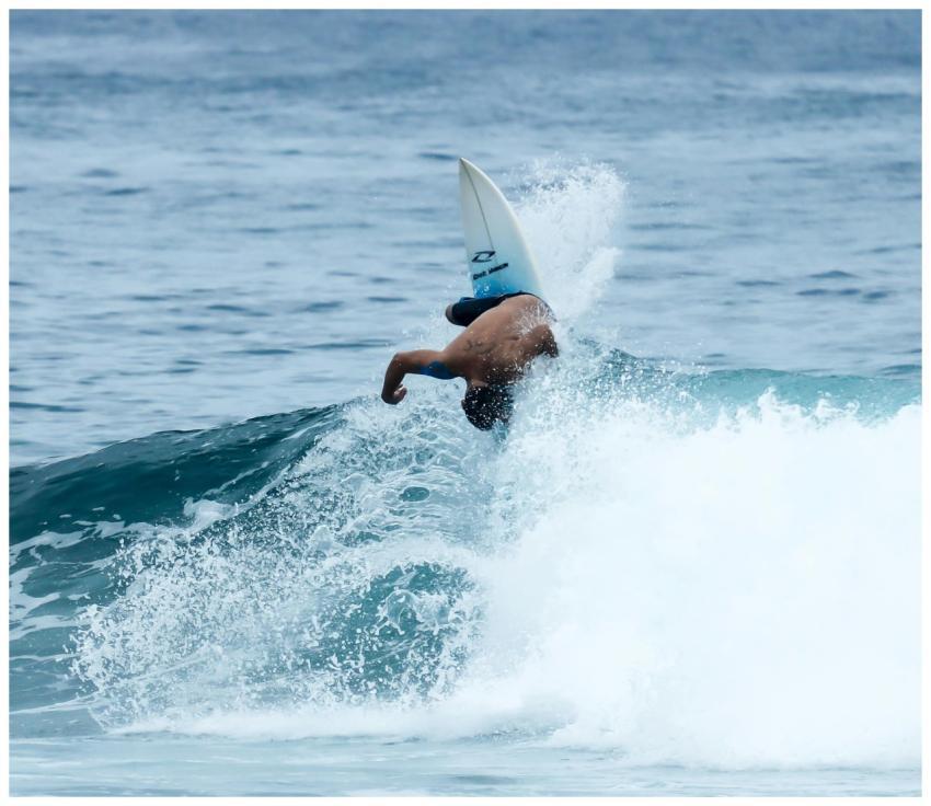 Surfer executing an acrobatic move on a wave in Br