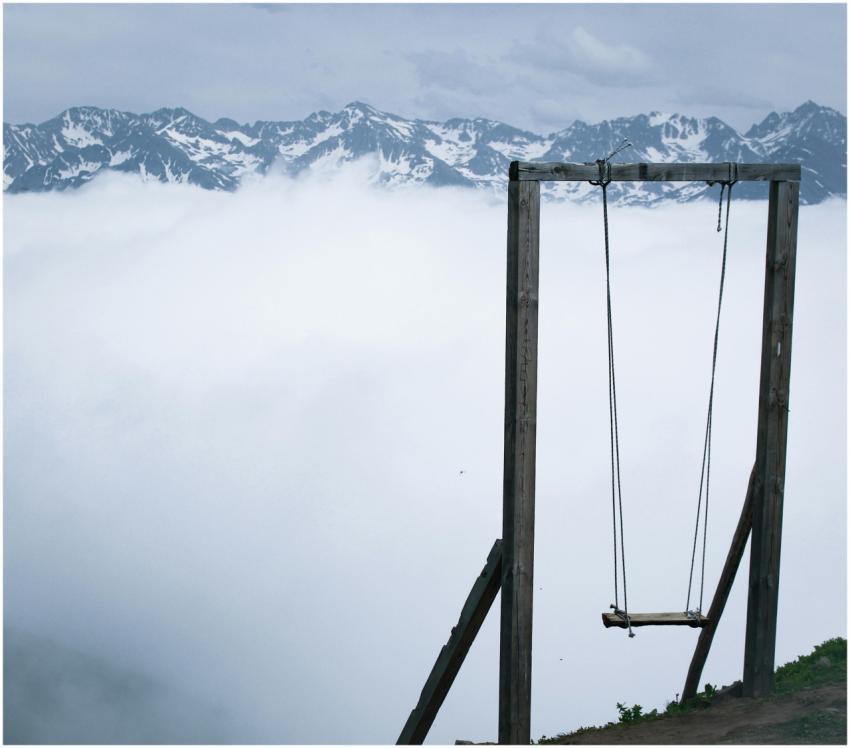 A solitary swing overlooks a mist-covered valley w