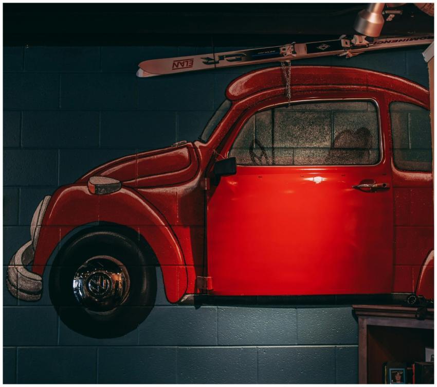 A vibrant mural of a vintage red car painted on an