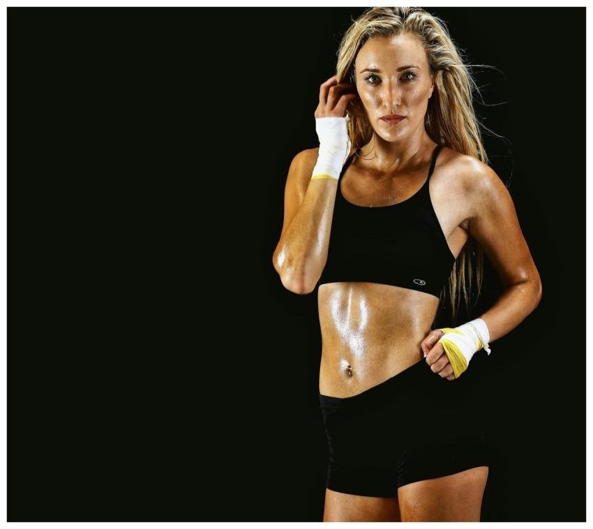 Strong athletic woman posing against a dark backgr