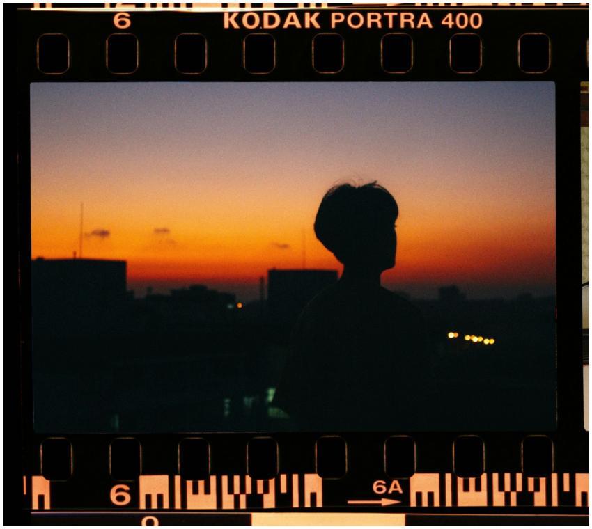 Silhouette of a person against a vibrant sunset, c