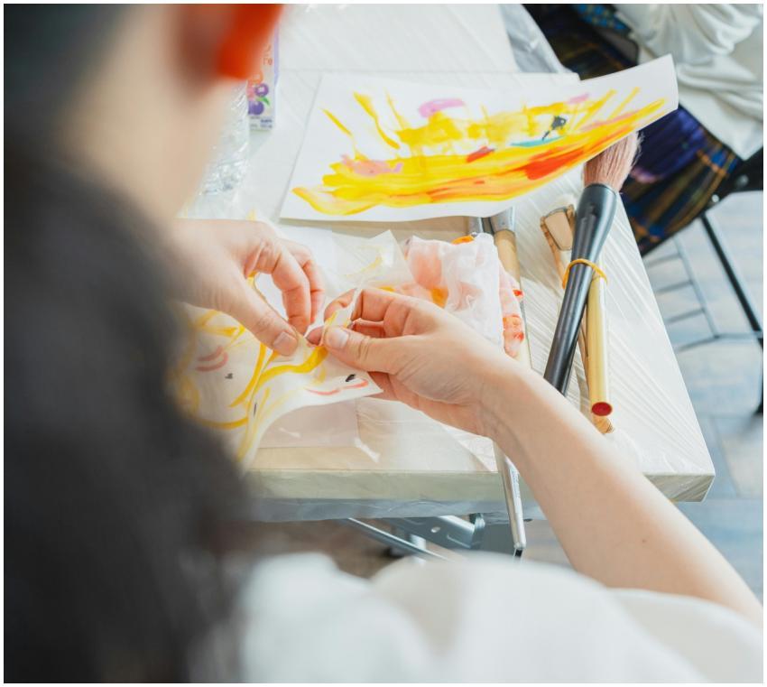 Artist creating vibrant artwork during a class in