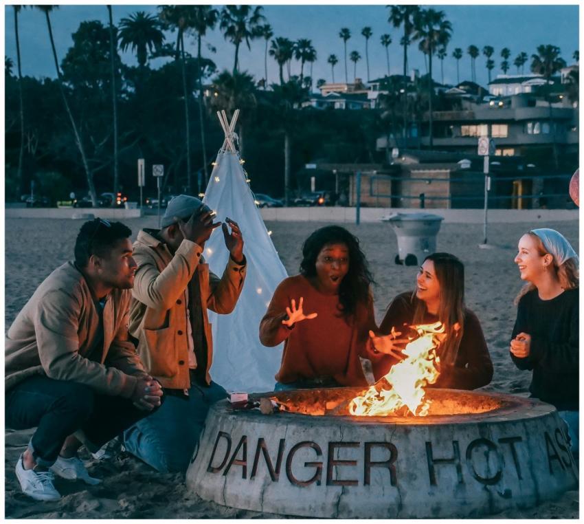 A diverse group of friends enjoying a bonfire on t