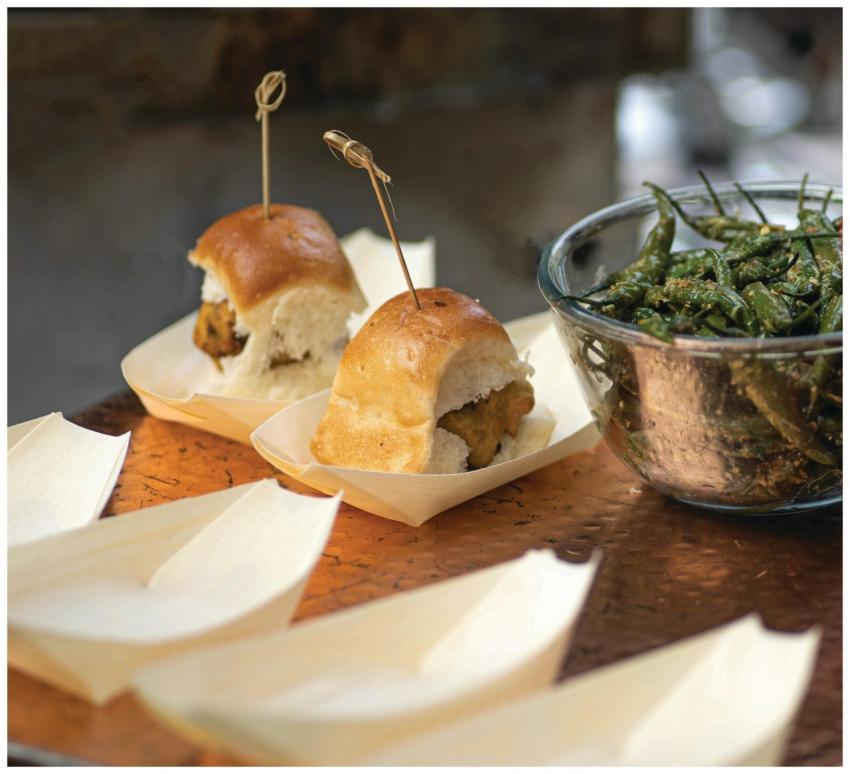 Vada pav served with fried green chilies, a popula