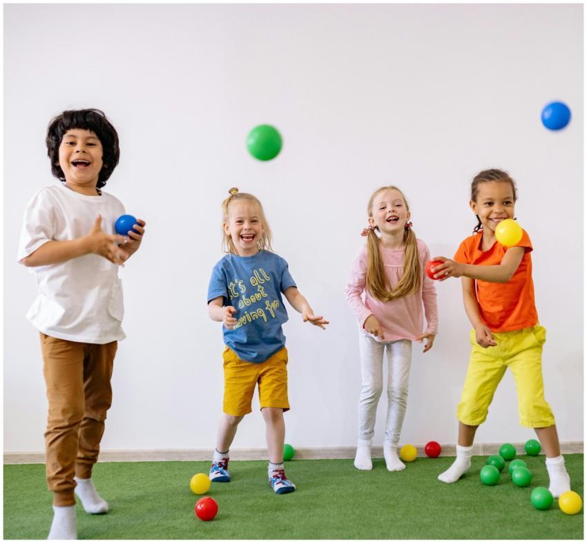 Four diverse children having fun with colorful bal