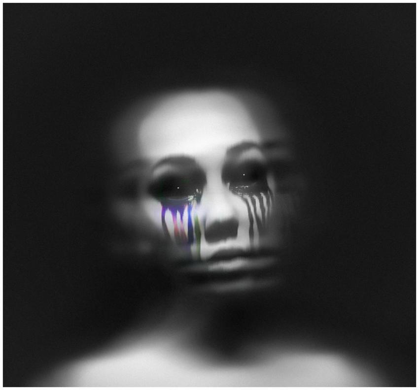 A blurred grayscale portrait with colorful tear-li