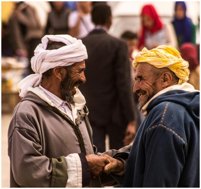 Two men sharing a joyful moment in a bustling Marr