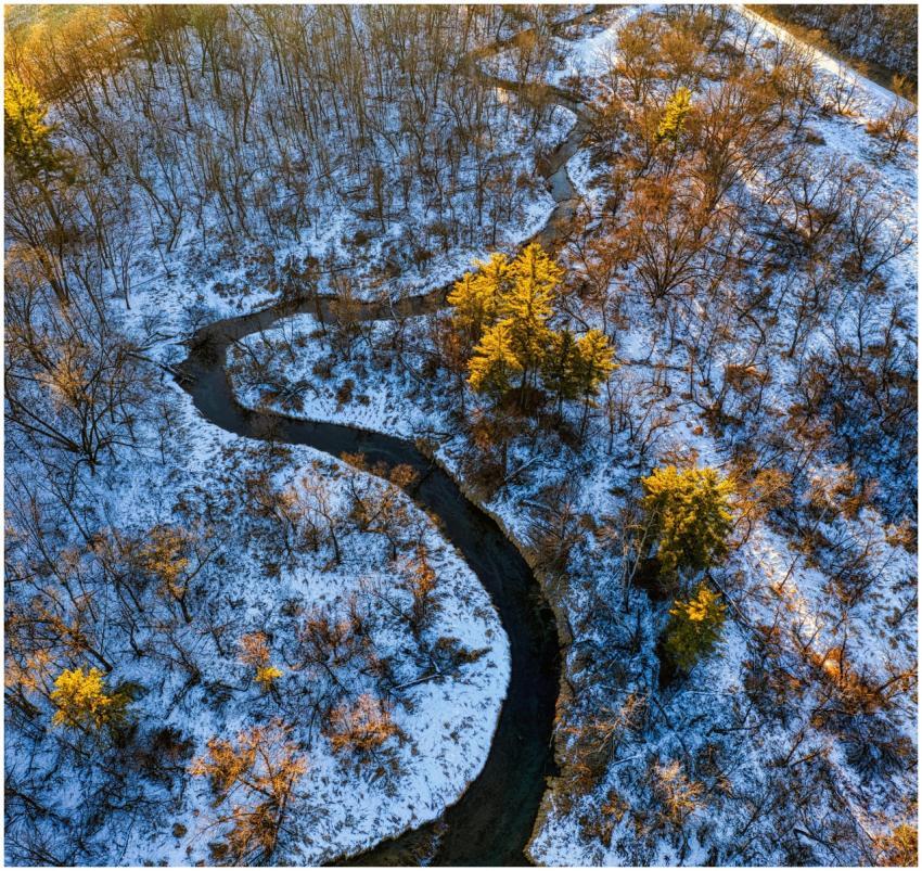 Captivating aerial view of a winding creek in snow