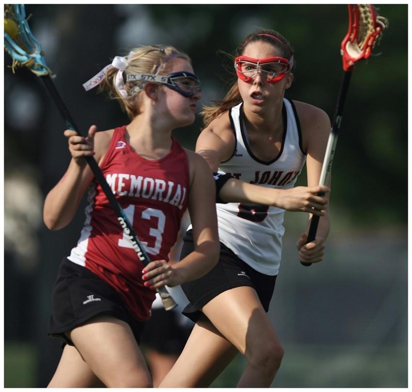 Two female lacrosse players in action outdoors dur