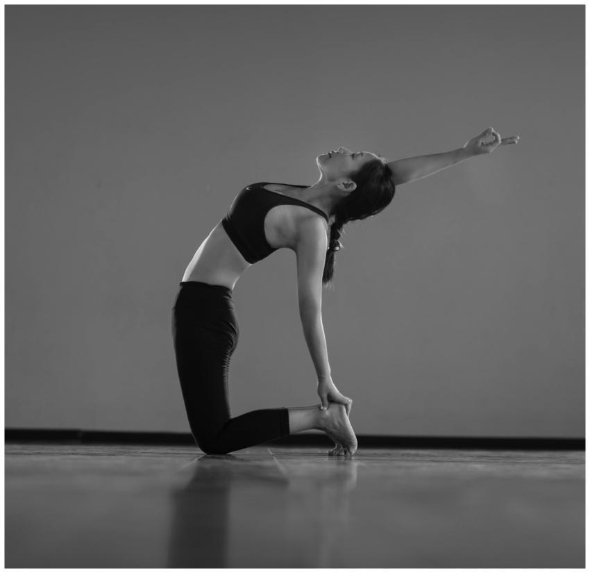 A woman gracefully performing a yoga pose indoors,