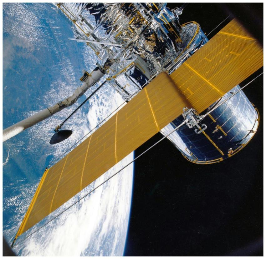 Spacecraft with solar panels orbiting Earth, showc