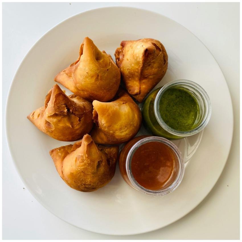 Top view of crispy samosas served with green and t
