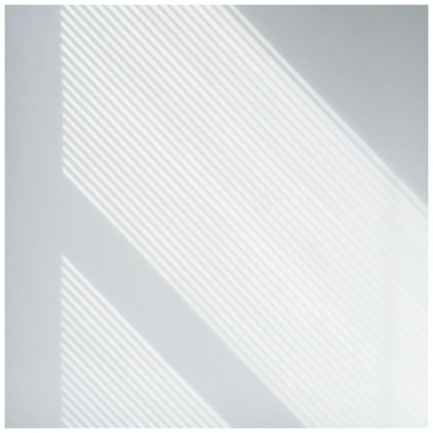 Soft natural light casting geometric shadows on a