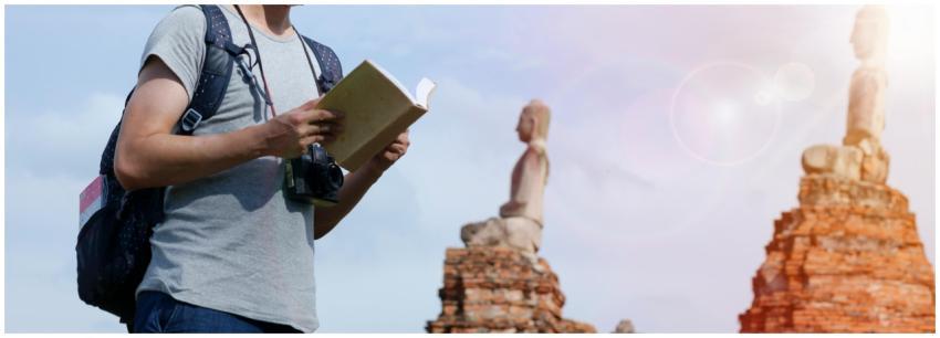 Man with a camera and book exploring ancient ruins