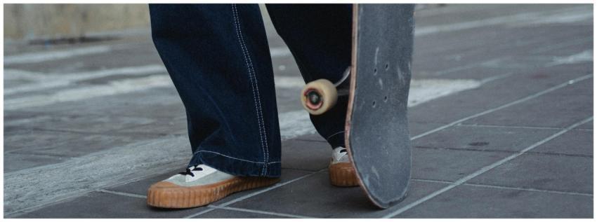 Unrecognizable male in jeans and sneakers with ska