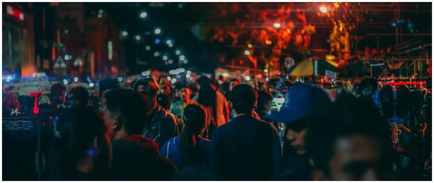 A bustling street market at night with crowds and